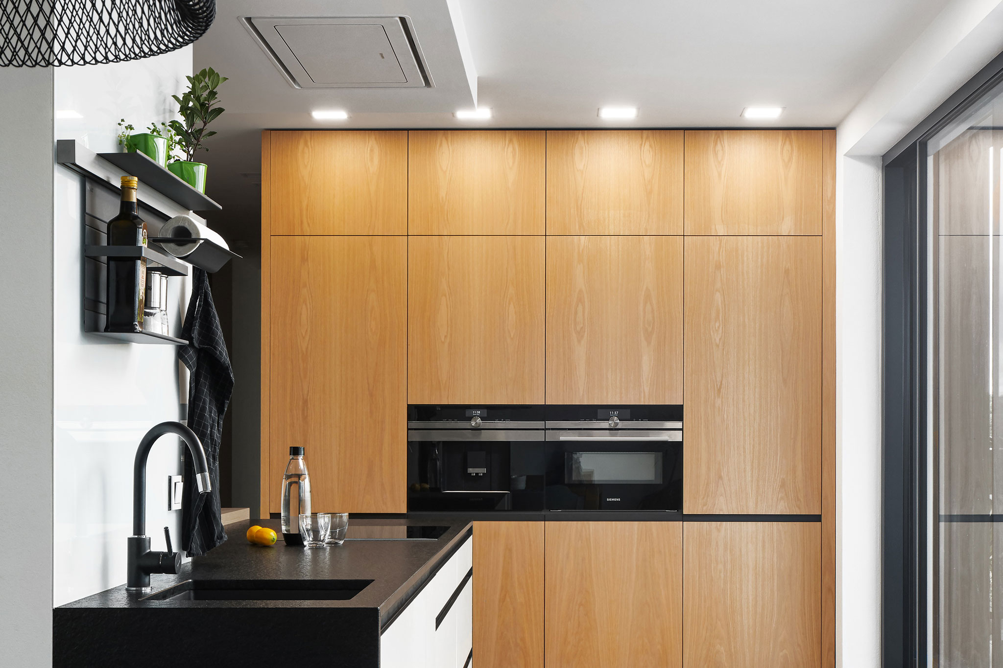 realizacia_moderna-kuchyna-na-mieru_biely-lak_drevene-skrine_cierna-3d-pracovna-doska_stropny-digesto