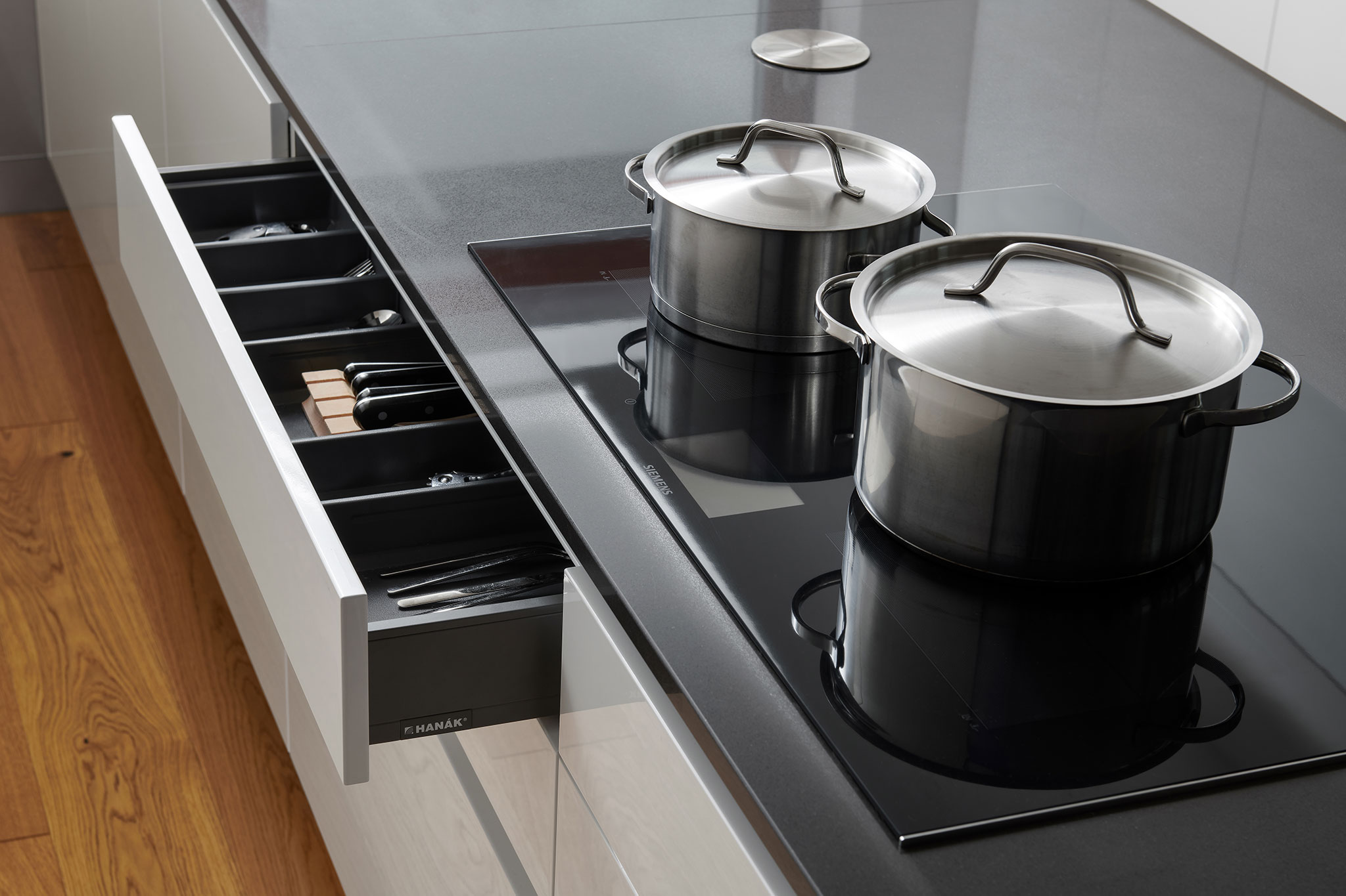 realizacia_moderna-kuchyna-na-mieru_minimalisticka-biela-lakovana-kuchyna_cierna-pracovna-doska